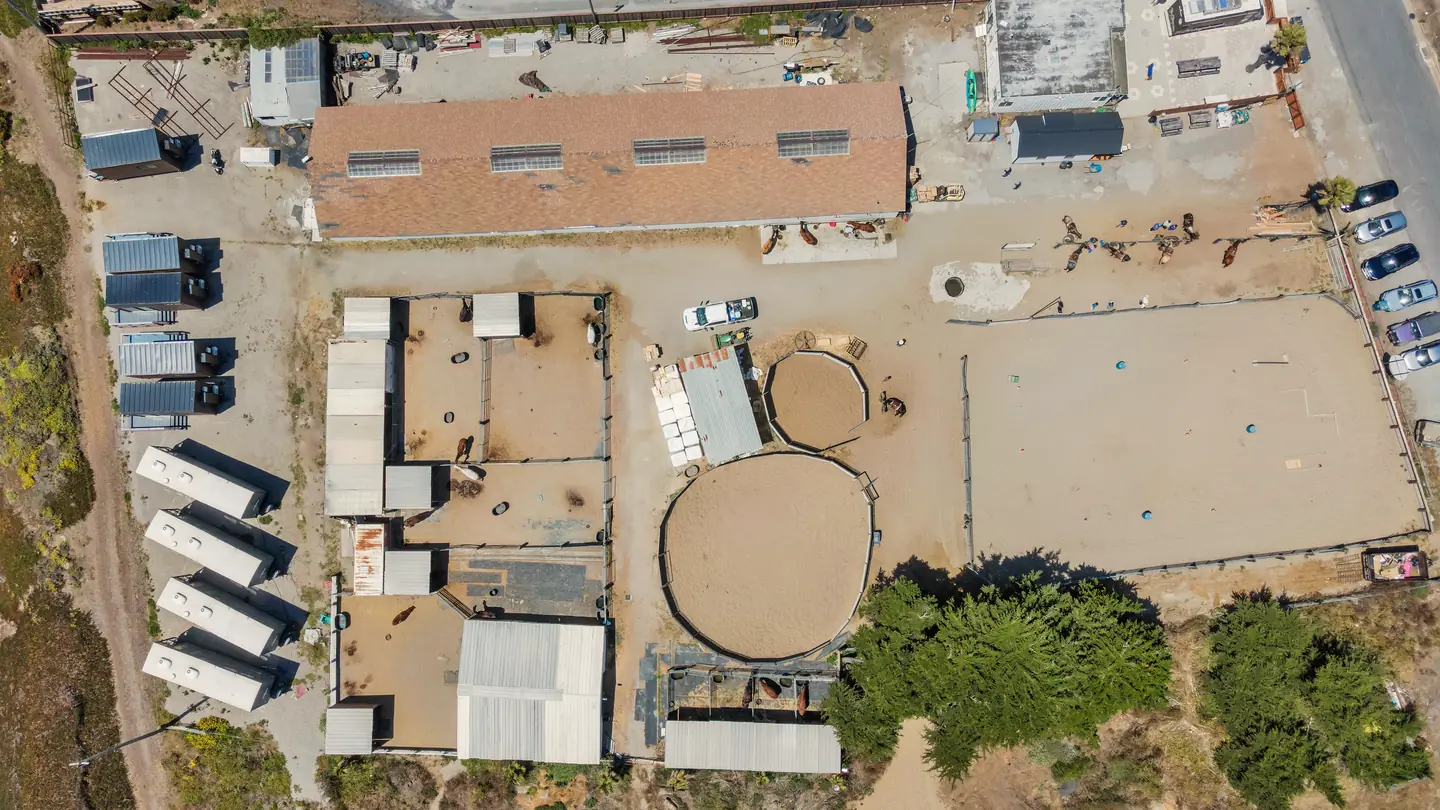 A stable seen from directly above: the barn, the round pens, the arena and the guest pods